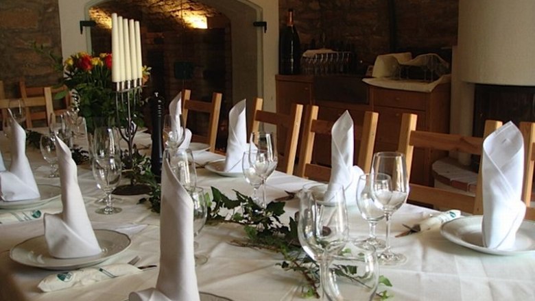 laid table, © Landgasthaus Hotel Muhr Elegant table with white napkins and wine glasses in a rustic room.