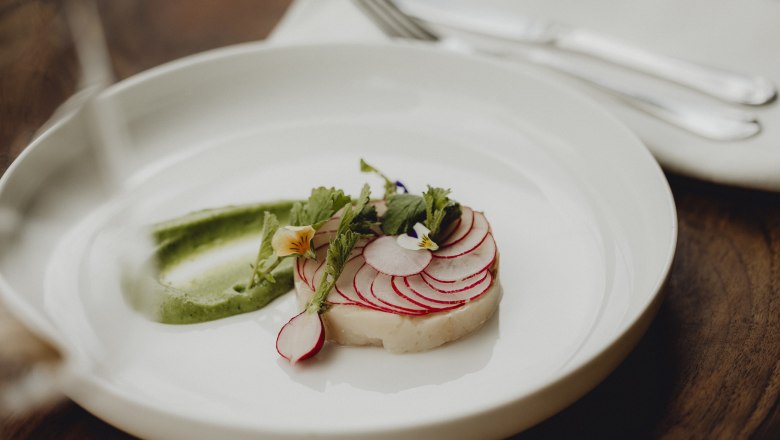 Great combination: char, wasabi, radish, © Niederösterreich Werbung/Sophie Menegaldo A dish with char, radishes and wasabi cream, decorated with edible flowers.