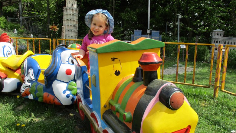On the carousel in the Hubhof family park, © Familienpark Hubhof Child on a colorful carousel train in the Hubhof family park.