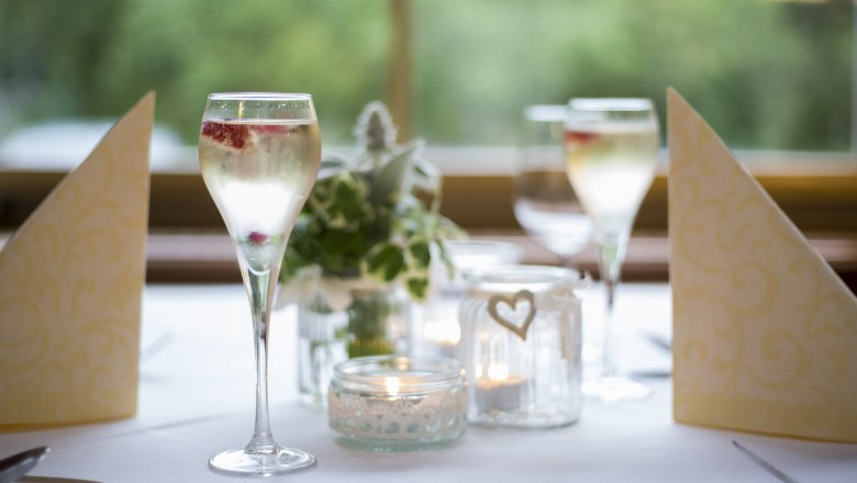 Alpen-Aktiv-Landgasthof zur Schubertlinde, © Patrick Haberler Elegant table decoration with champagne glasses, candles and napkins.