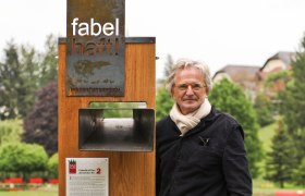 Fabulous signs in the Bucklige Welt, © Nikolaus Pfusterschmid A man stands next to a wooden sign with the words 'fabulous' in a park.
