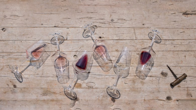 Wines, © Weinviertel Tourismus / Doris Schwarz-König_klein Overturned wine glasses with red wine on a wooden table.