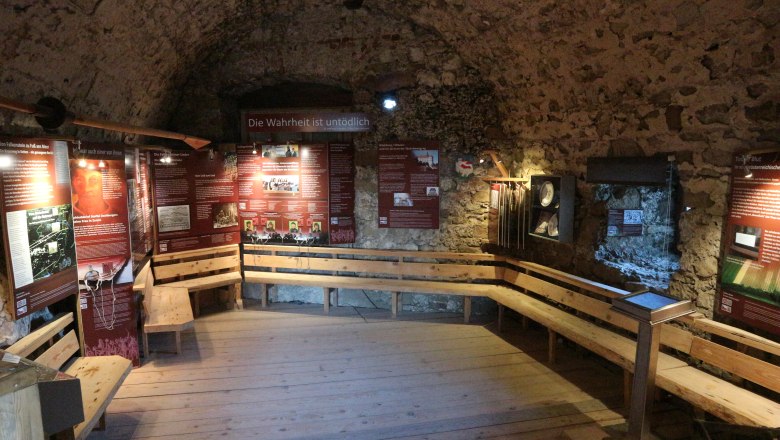 Anabaptist vault, © Aline Luckner Historical room with information boards and wooden benches.