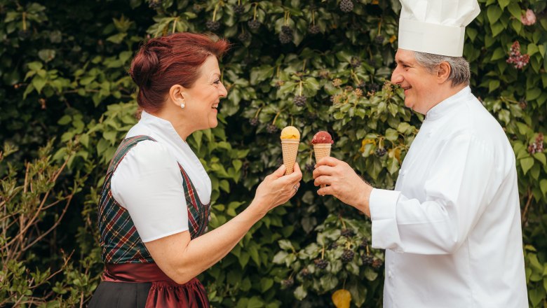 Ice cream, pasta, chutneys - all made by hand, © Niederösterreich Werbung/Daniela Führer Two people holding ice cream cones and smiling at each other against a background of green leaves.