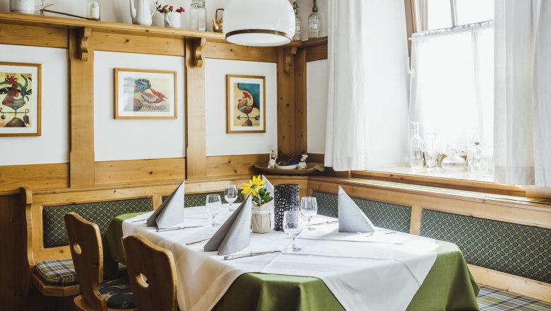 Parlor with regulars' table, © Niederösterreich Werbung/David Schreiber Cozy living room with wooden furniture, table setting and pictures on the wall.