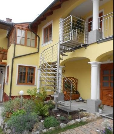 Spiral staircase, © Fam. Schwalm Yellow house with spiral staircase and garden.