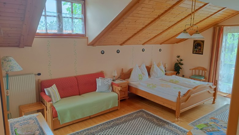 Attic room in the Sundl house, © Margit Siebenhandl Room with sloping ceiling, double bed and sofa bed