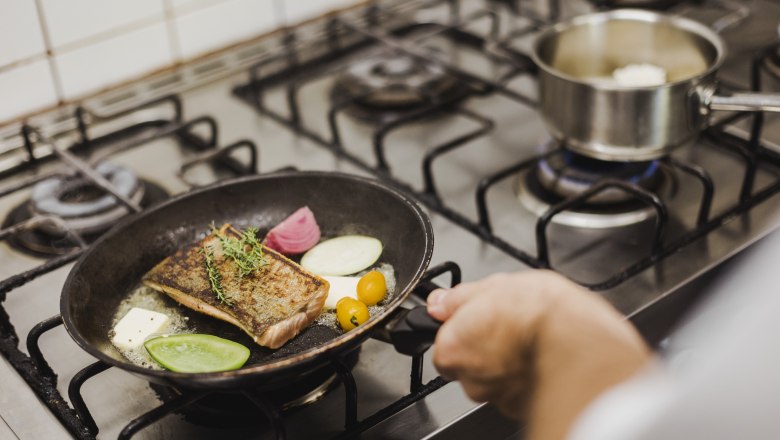Delicacy menu, © Niederösterreich Werbung/David Schreiber A pan with fish, vegetables and herbs on a stove.