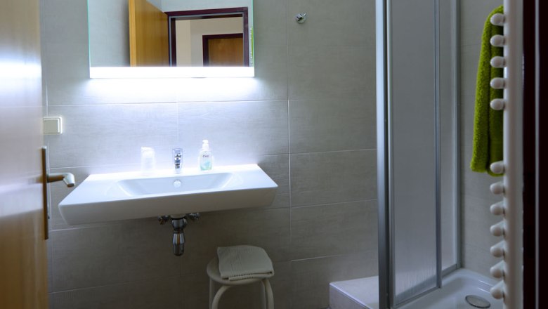 Bathroom at Gasthof Schmied Smolka, © Gasthof Schmied Smolka Modern bathroom with washbasin, illuminated mirror and shower.