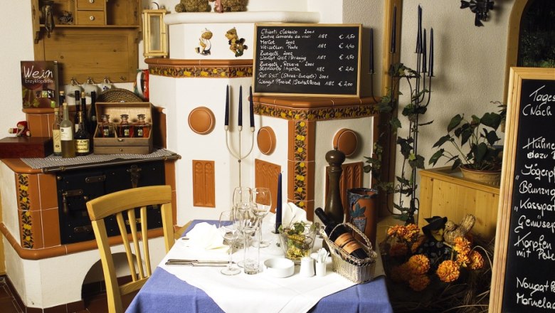 Fireside lounge, © Landgasthof Oppolzer Cozy fireside lounge with set table, wine lists and decorations.