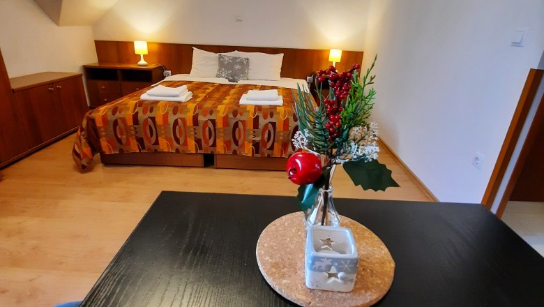 Double room(c)Ildiko Davidne Nagy, © Ildiko Davidne Nagy A cozy double room with a decorated table in the foreground and a bed in the background.