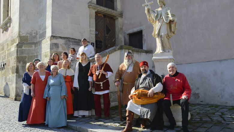 Medieval town tour, © Stadtführer-Hbg Group of people in medieval clothing in front of a statue in an old town.