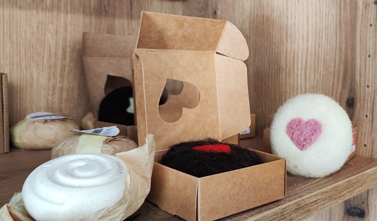 Mobile farm store with lovingly made products, © Wiener Alpen Handmade soaps and decorations with heart motifs on a shelf.