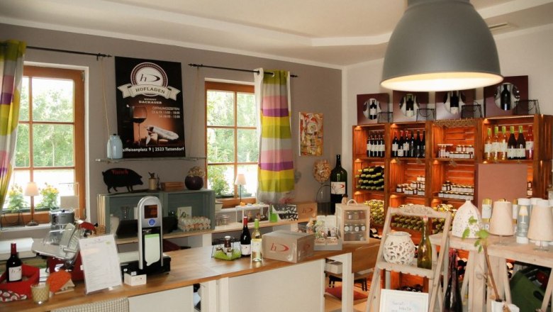 The farm store, © Weingut Dachauer Interior view of a farm store with shelves full of wine bottles and products.
