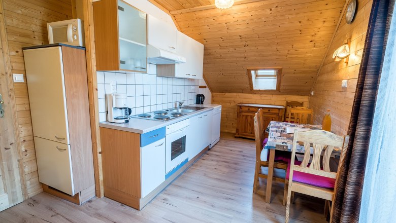 Apartment "Sonnenschein" Kitchen, © Familie Morgenbesser Kitchen with wood paneling, dining table and kitchenette.