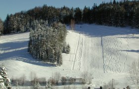Kalte Kuchl ski area, © Alpengasthof Kalte Kuchl Snow-covered ski slope with forest in the background.