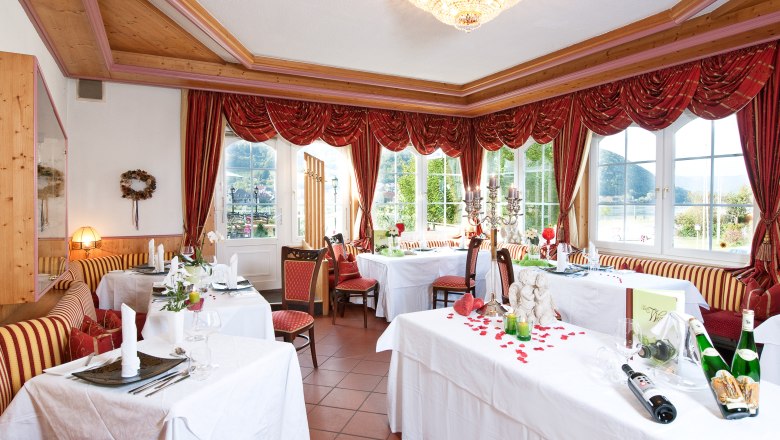 Residence Wachau - Restaurant, © Residenz Wachau Elegant restaurant with laid tables, red curtains and chandeliers.