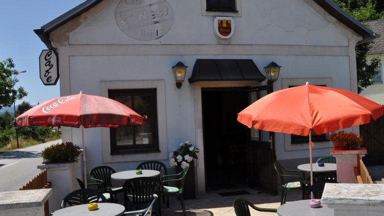 Nest outside, © Thermengemeinden Exterior view of a café with terrace, tables and parasols.