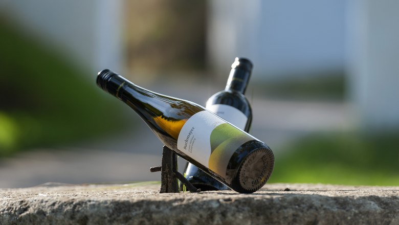 Buchmayer Winery, © Michael Himml Two wine bottles on a stone, one lying at an angle, the other in the background.
