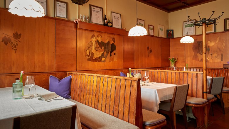 Rustic pub parlor, © Niederösterreich Werbung/Andreas Hofer Cozy restaurant with wooden benches, tablecloths and wall decorations.