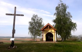 Power place St. Peter am Stein, © Robert Appoyer A wooden cross and a small chapel on a hill with trees and a wide view over the landscape.
