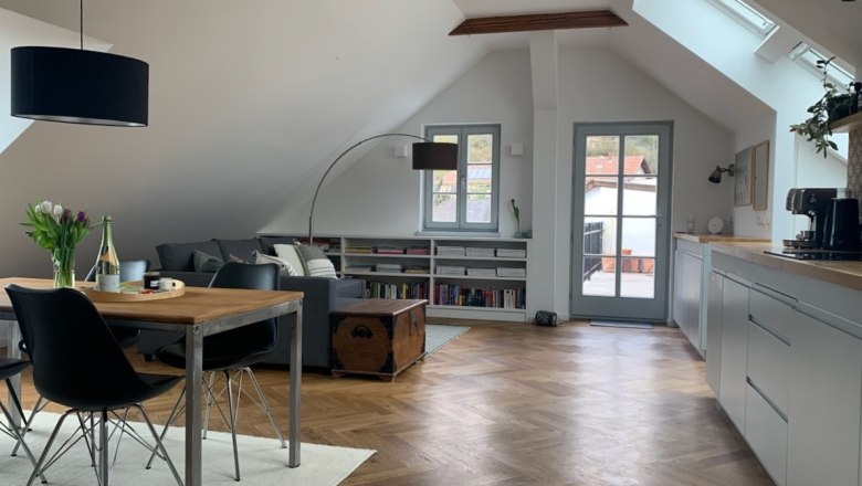 Apartment on the upper floor, "Amazing View", © kremsoase Modern attic apartment with wooden floor, dining table, sofa and access to a balcony.