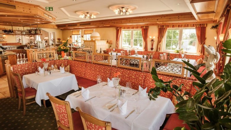 Restaurant area Wachauer Stube, © Hotel Wachau Elegant restaurant with laid tables and red upholstered furniture.