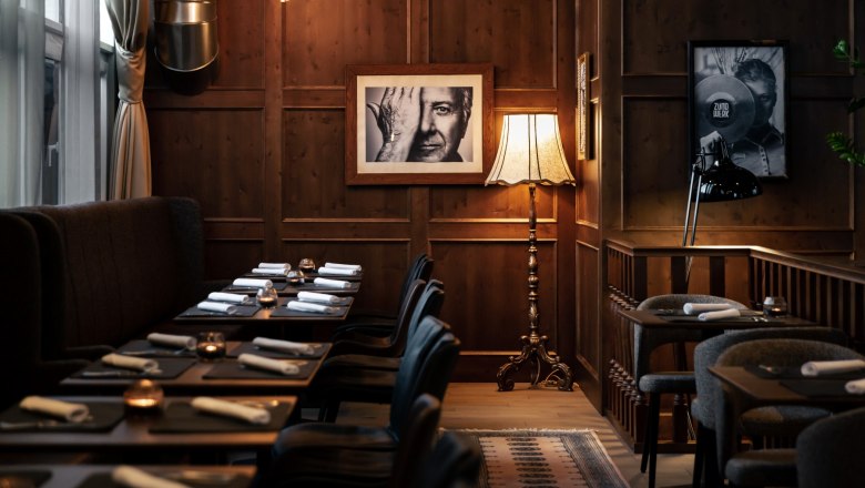 Living Room, © Derenko Design Cozy room with wooden walls, set tables, floor lamp and black and white photographs on the wall.