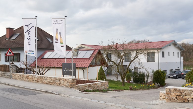 Exterior view, © Weinhof Maier Exterior view of a building with red roofs and two flags in front of it.