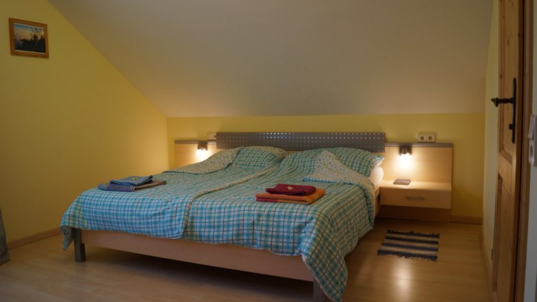 Maple room, © Reep Bedroom with double bed, checkered comforters and bedside lamps.