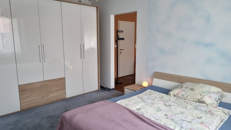 Double room, © Wolfgang Greil A bedroom with a double bed, a large white closet and a bedside lamp.