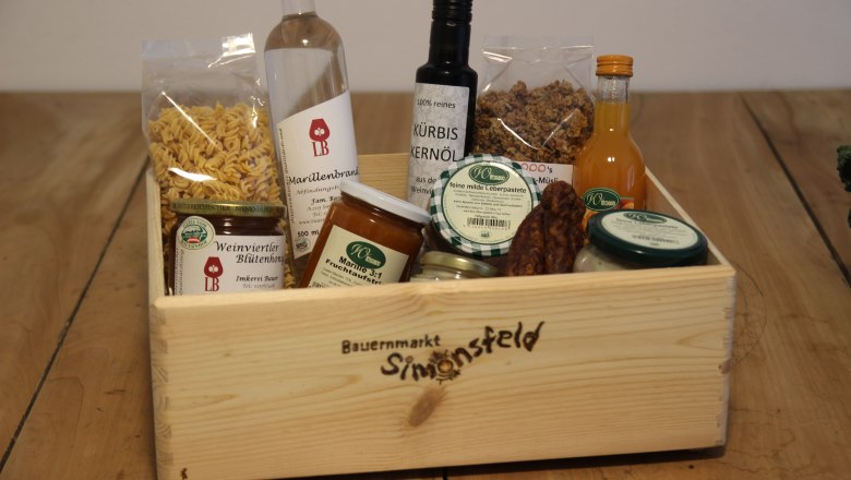 Colorful assortment, © Josef Popp Wooden box with regional products such as oil, honey, jam and pasta.