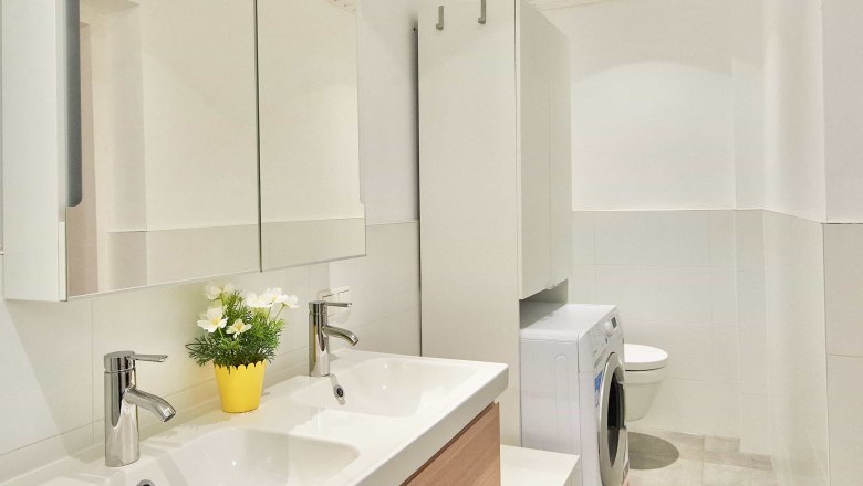 Top 1 - Bathroom, © VP FeWo OG Modern bathroom with double washbasin, mirror, washing machine and WC.