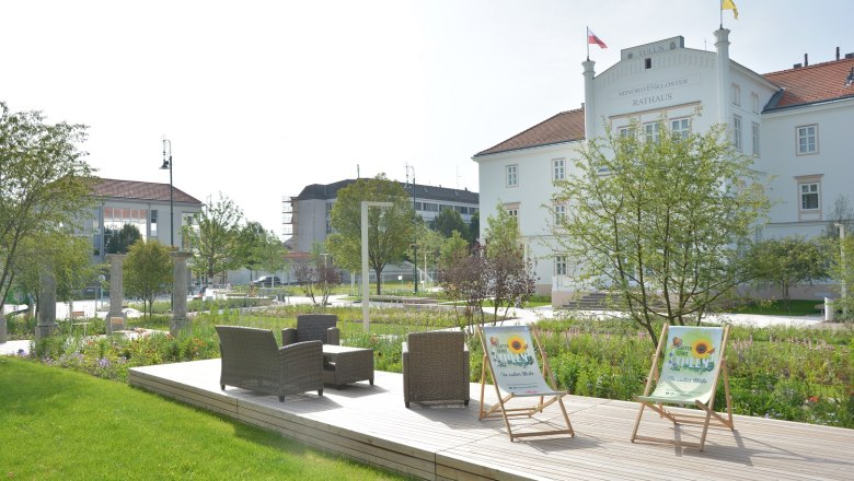 Tulln's Nibelungenplatz, © Stadtgemeinde Tulln Wooden seating island on Nibelungenlplatz with table and chairs