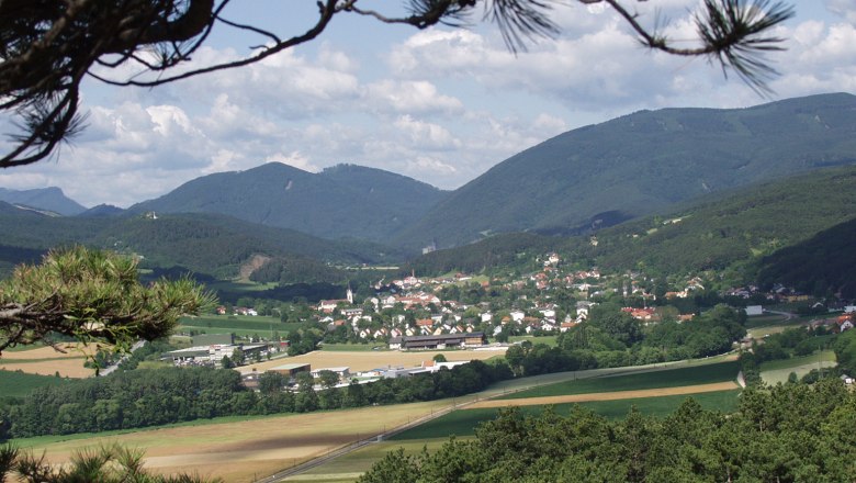 Market Piesting, © Gemeinde Markt Piesting View of Markt Piesting with surrounding fields and mountains in the background.