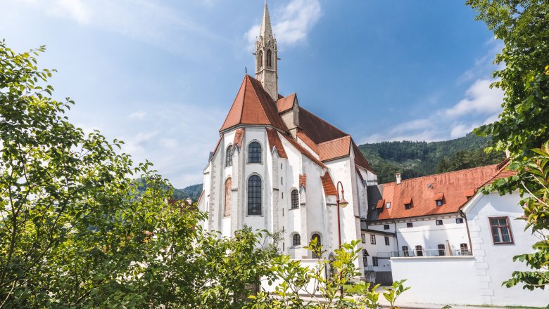 Hotel Kartause Gaming, © Ricarda Schwarzel Historic building with red roof and tower, surrounded by trees.