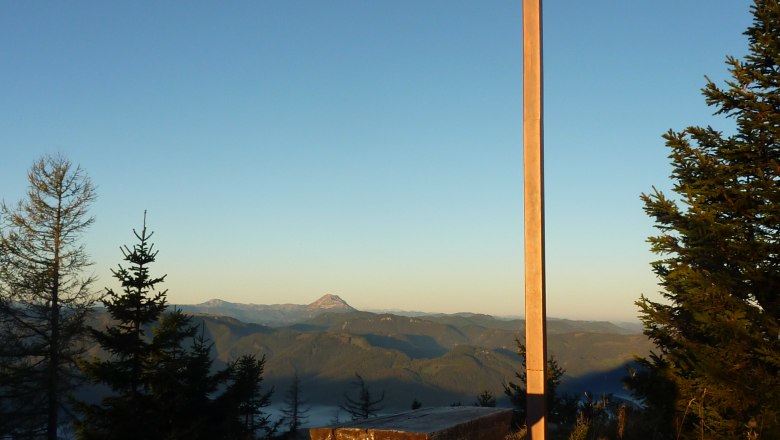 Summit cross on the Türnitzer Höger, © Gebirgsverein St.Pölten Summit cross on the Türnitzer Höger with wooden benches and mountain panorama in the background.