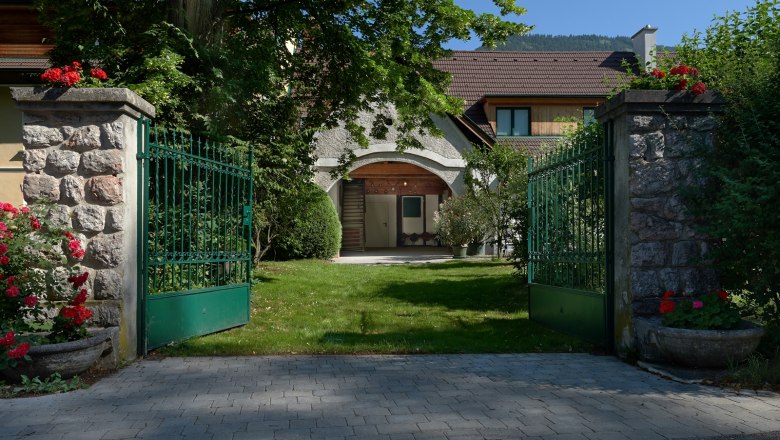 Driveway, © Landhaus Puchbergerhof by smc Open green gate leads to a house with garden.
