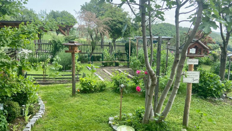Apartments Riedl, © Wiener Alpen A well-kept garden with trees, flowers and a bird house.