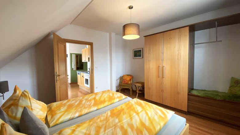 Vacation apartment Marille, © Trachsler Bedroom with double bed, closet and view into the kitchen.