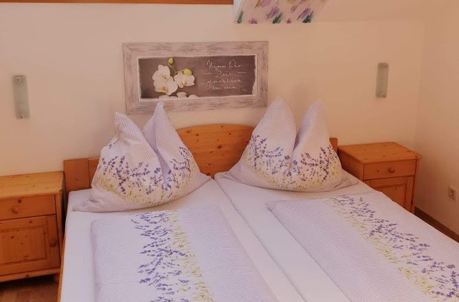 Krell Winery, © Weingut Krell Cozy bedroom with skylights and floral bedding.