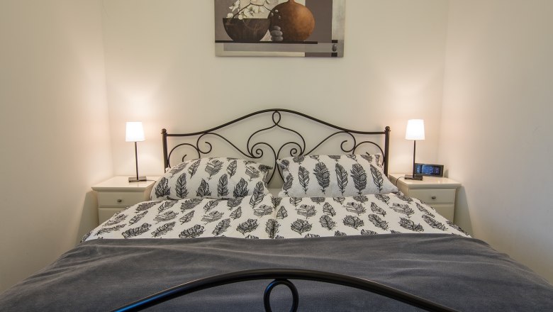 Vacation apartment, © A. Dirnbauer Bedroom with double bed, two bedside tables and lamps.