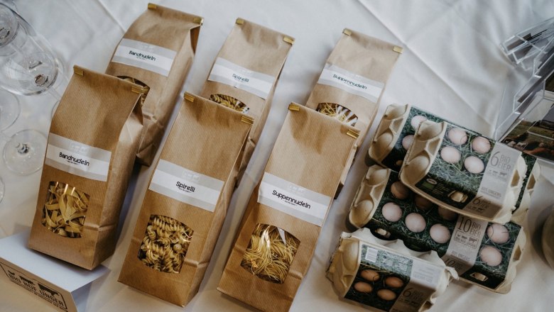 Biohof Unger, Products, © Biohof Unger Products from Biohof Unger: pasta in brown bags and egg cartons on a table.