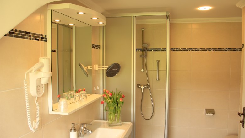 Bathroom, © Schendl Modern bathroom with shower, washbasin, mirror and tulips.
