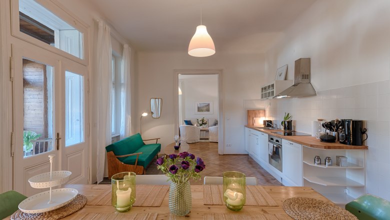 Top 1 - Kitchen, © VP FeWo OG Bright kitchen with dining table, sofa and view into the bedroom.