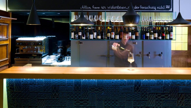 TDR-The Wolf Bar, © Das Wolf Bar with many bottles of wine in the background and bartender