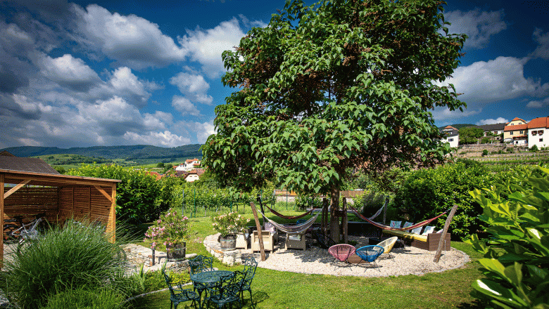 Garden at the Hotel Weinquadrat, © ivan-lukacic-photography Garden at the Hotel Weinquadrat with tree, hammocks and seating area.