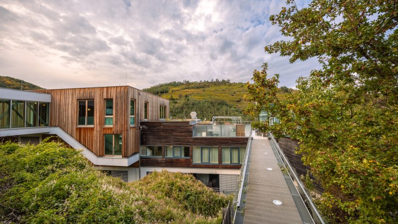 Steigenberger Hotel & Spa, Krems, © Niederösterreich Werbung / Maximilian Pawlikowsky Steigenberger Hotel & Spa in Krems with wooden façade and surrounding nature.