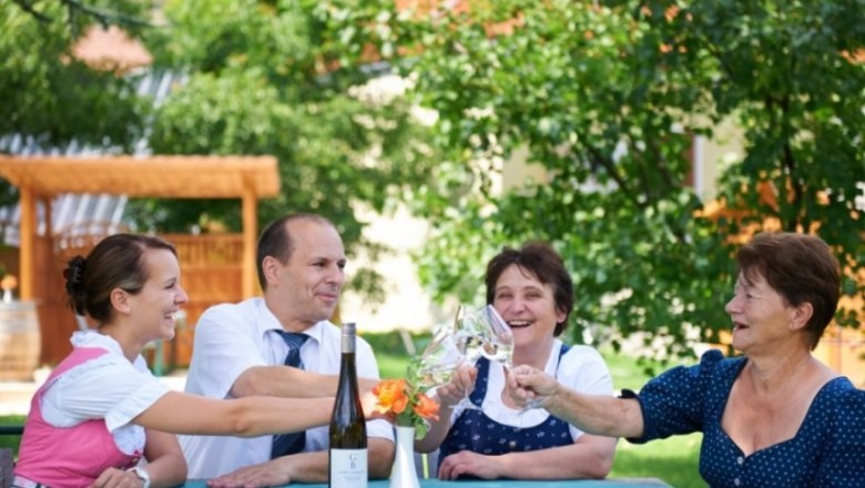 Wachau wine, © Paul Reiböck Four people clink glasses of wine outside.
