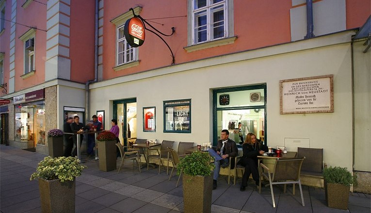 Colibri with sidewalk café, © Susanne Karas Street café with people sitting outside.